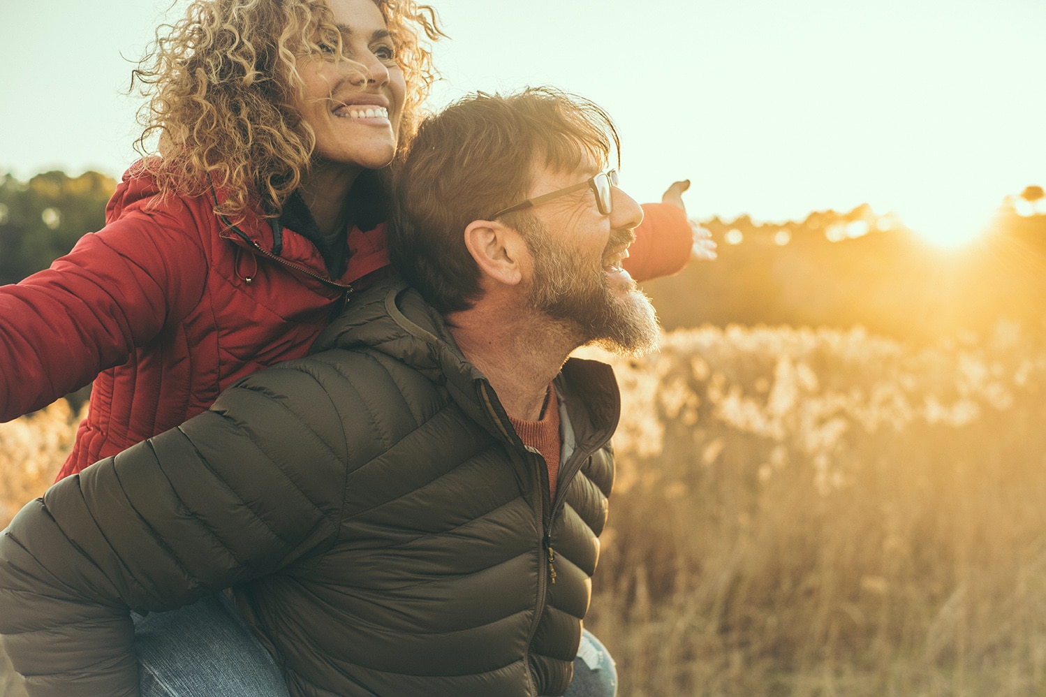 woman smiling on husbands back in a field in franklin tn