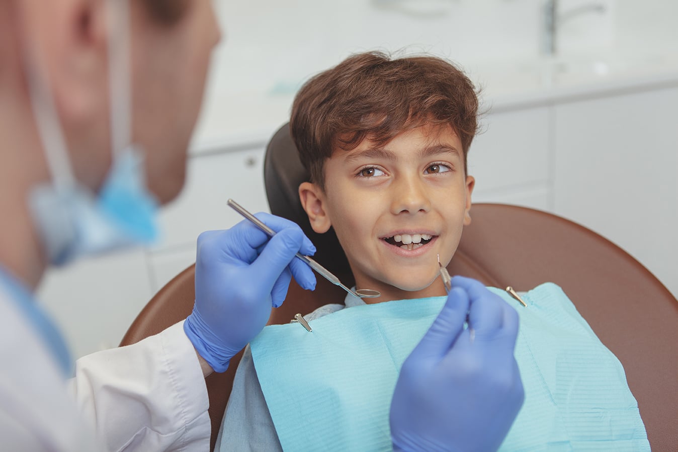 younch child talking with dr kelly during tooth-colored filling procedure at kelly family dentistry