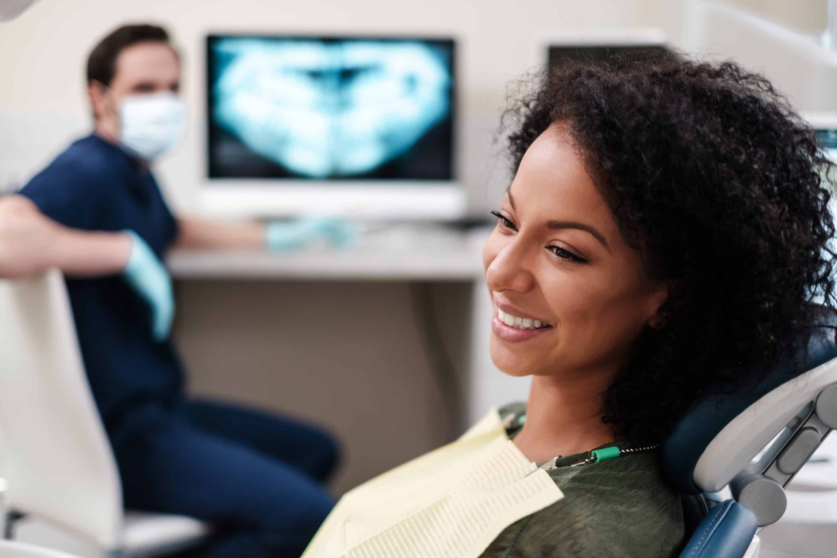 dental patient smiling with dr kelly while looking at dental xrays at kelly family dentistry in franklin tn