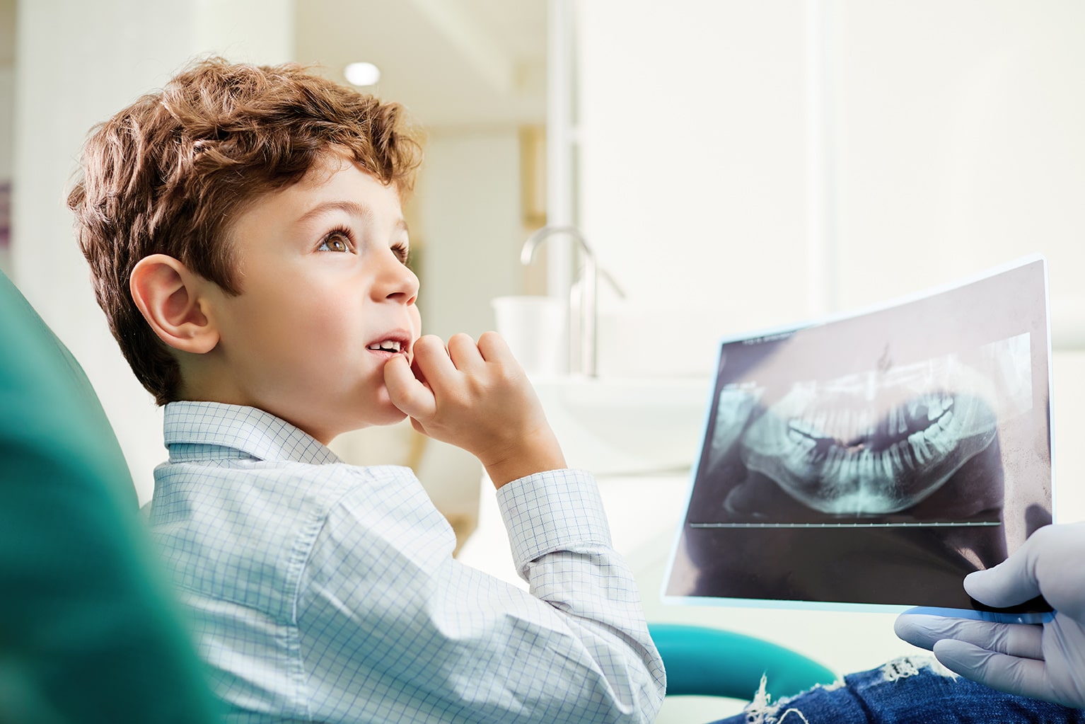 young dental patient looking at dental xray during pediatric dental appointment at kelly family dentistry