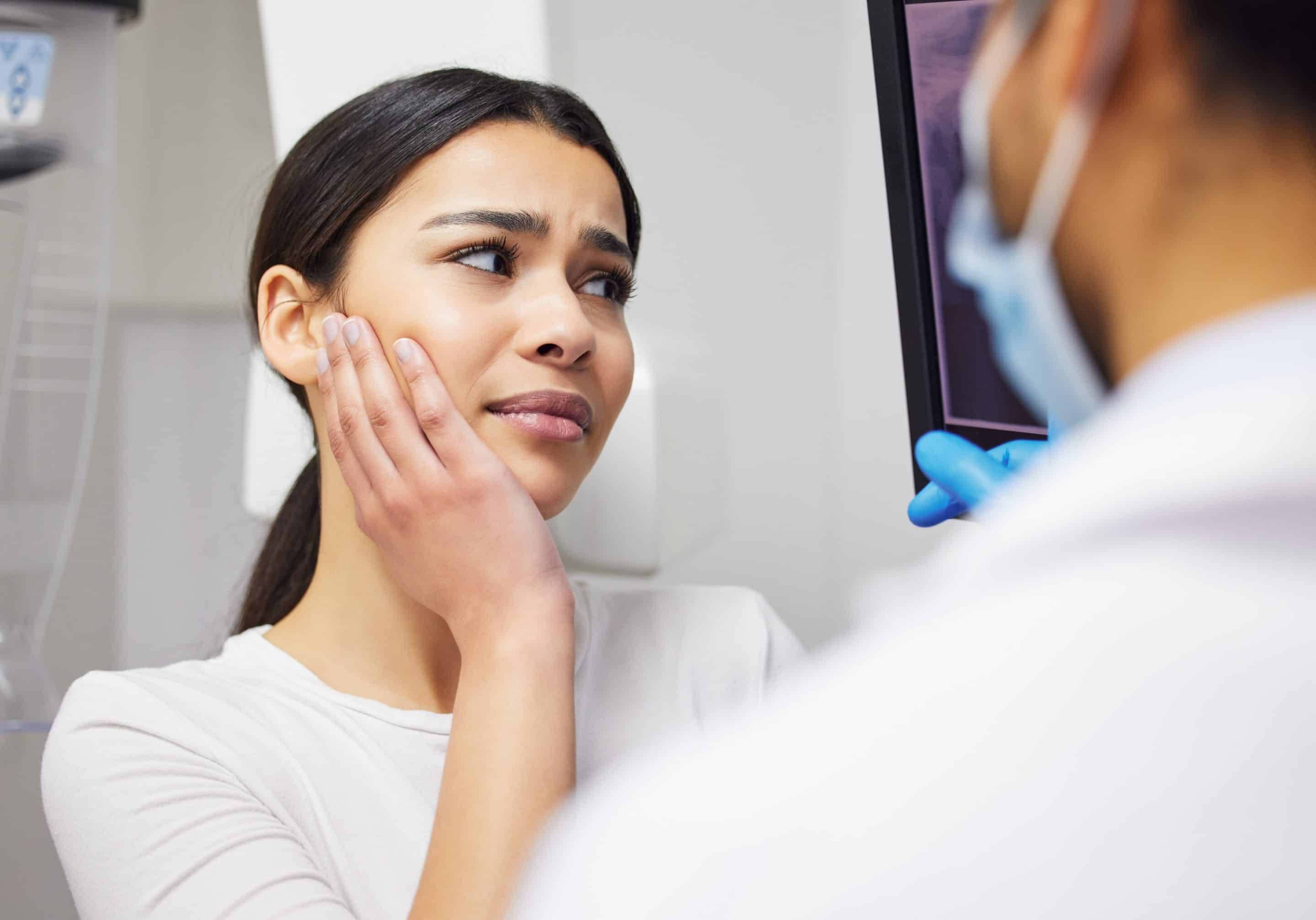 dental patient with tooth pain talking with dr kelly during dental crown appointment